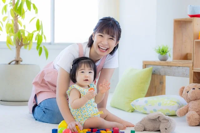 保育教諭と赤ちゃんが積み木で遊ぶ様子